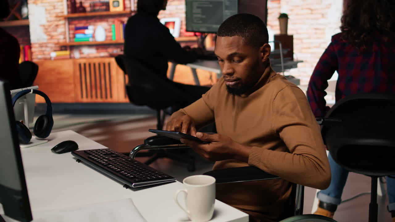 Inclusive software development agency worker with paraplegia uses tablet