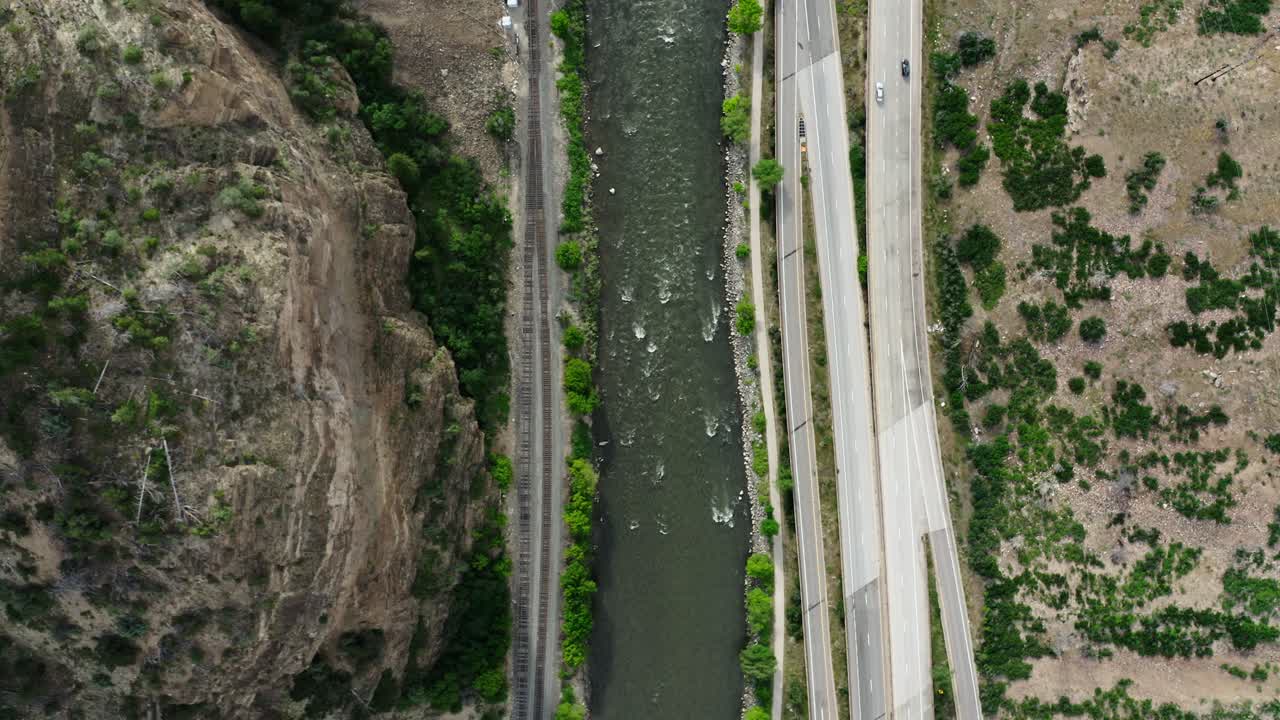 Top down drone shot of cars driving along the Colorado River on Interstate 70