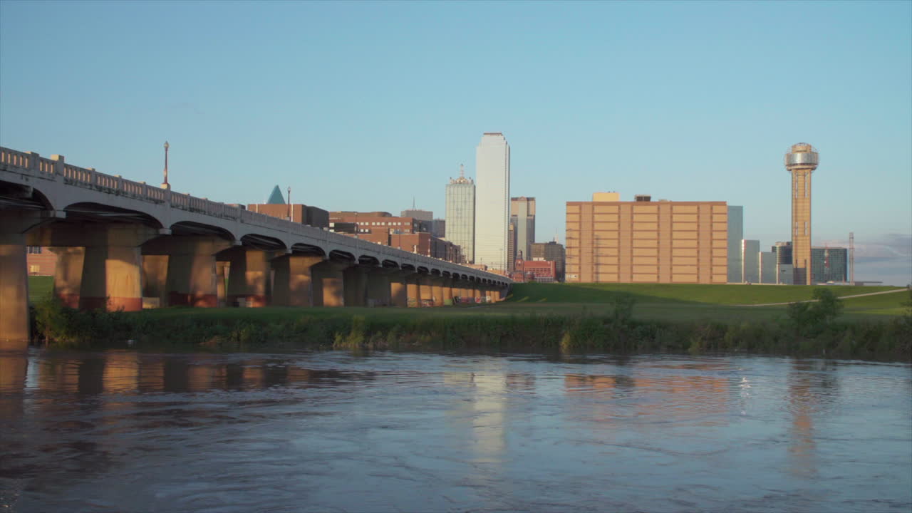 일몰 동안 전경에 트리니티 강이 있는 달라스 스카이라인