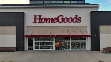 home goods storefront building in american town. cloudy summer day in american suburb. aerial rising wide shot.