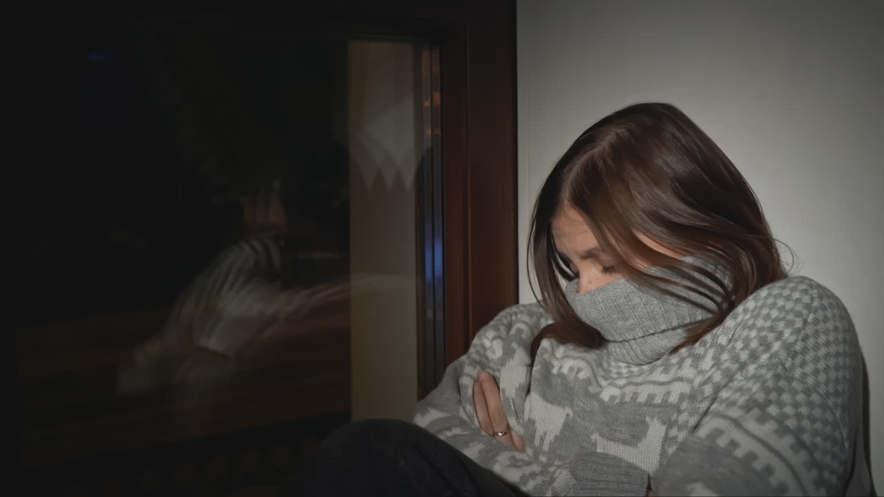 한 젊은 여성이 창문 에서 슬프고 혼자 보인다.