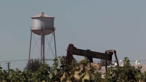 Bomba-De-Aceite-En-Viñedo-Con-Torre-De-Agua-En-California