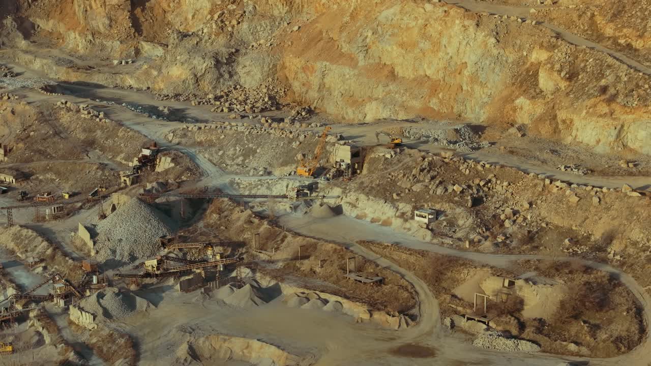 Stone quarry aerial close up shot showing winding roads and heavy machinery