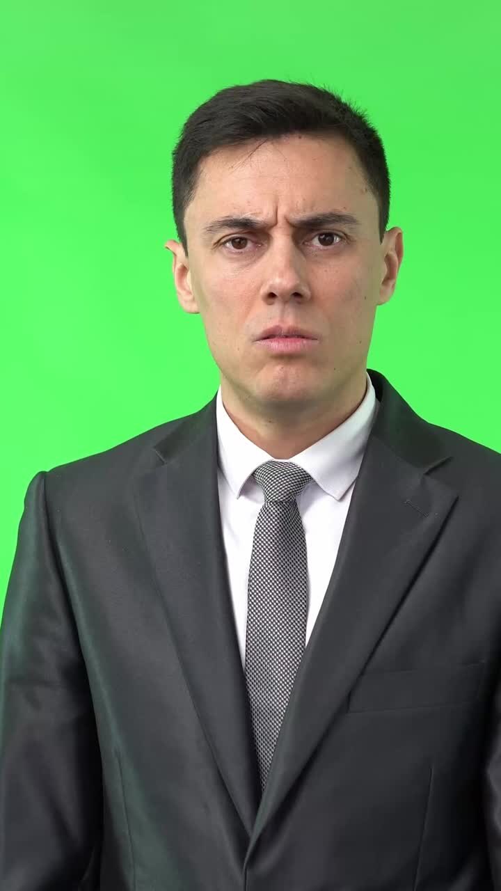 Uomo in abito che reagisce con disgusto e repulsione su schermo verde