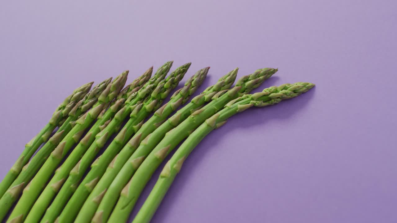 Video di asparagi freschi con spazio per il testo su sfondo lilla.
