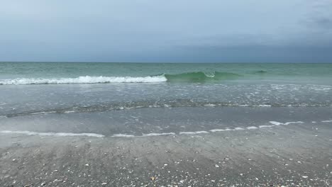 un día relajante al lado del océano en la playa de arena mientras las olas llegan