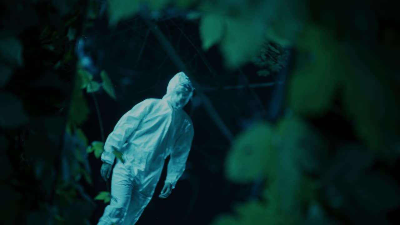 Mysterious Figure in Protective Suit Behind Glass