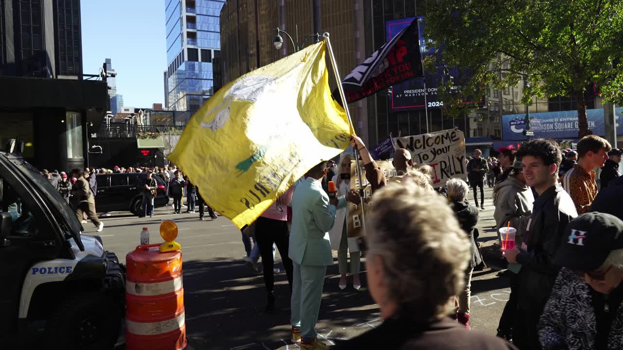 Protesters pack the streets around Madison Square Garden, the sunlight casting a warm glow over the tense crowd, all rallying against Trump