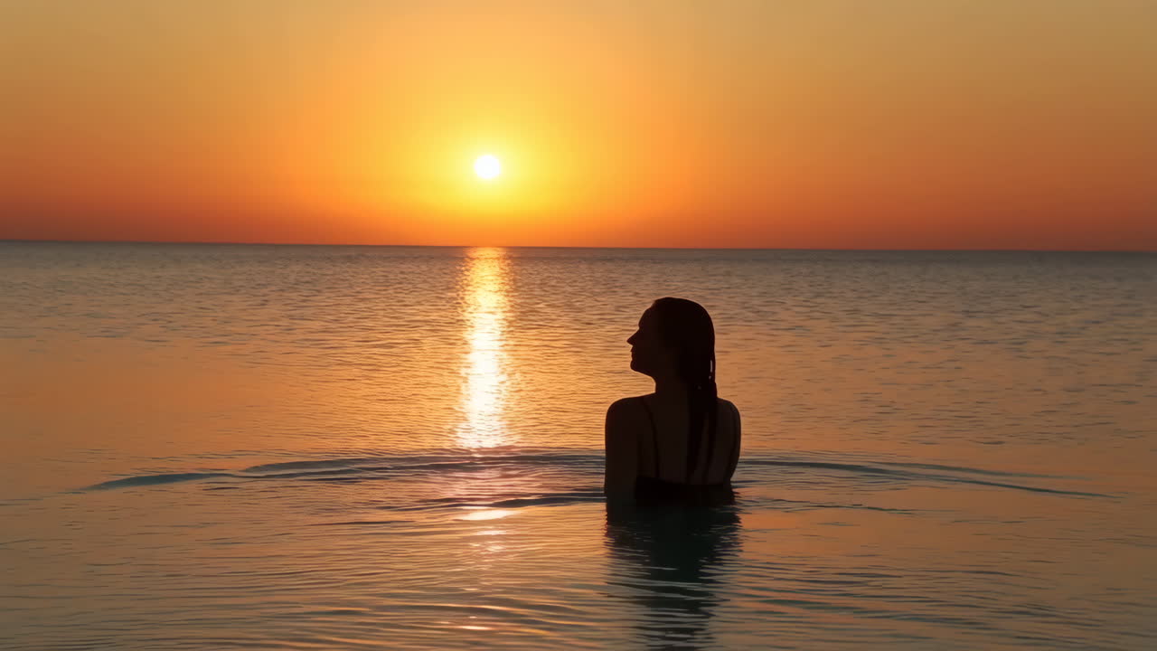 Woman Silhouette in the Ocean at Sunset