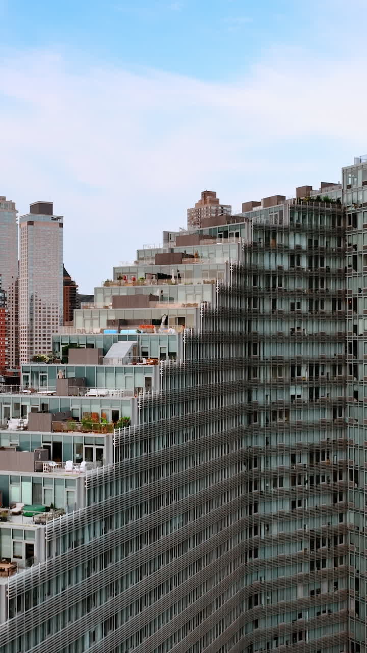 Staircase design of the huge grey multistoried building of New York. Lounge zones, car parks on the tops of the houses. Skyscrapers at backdrop. Vertical video