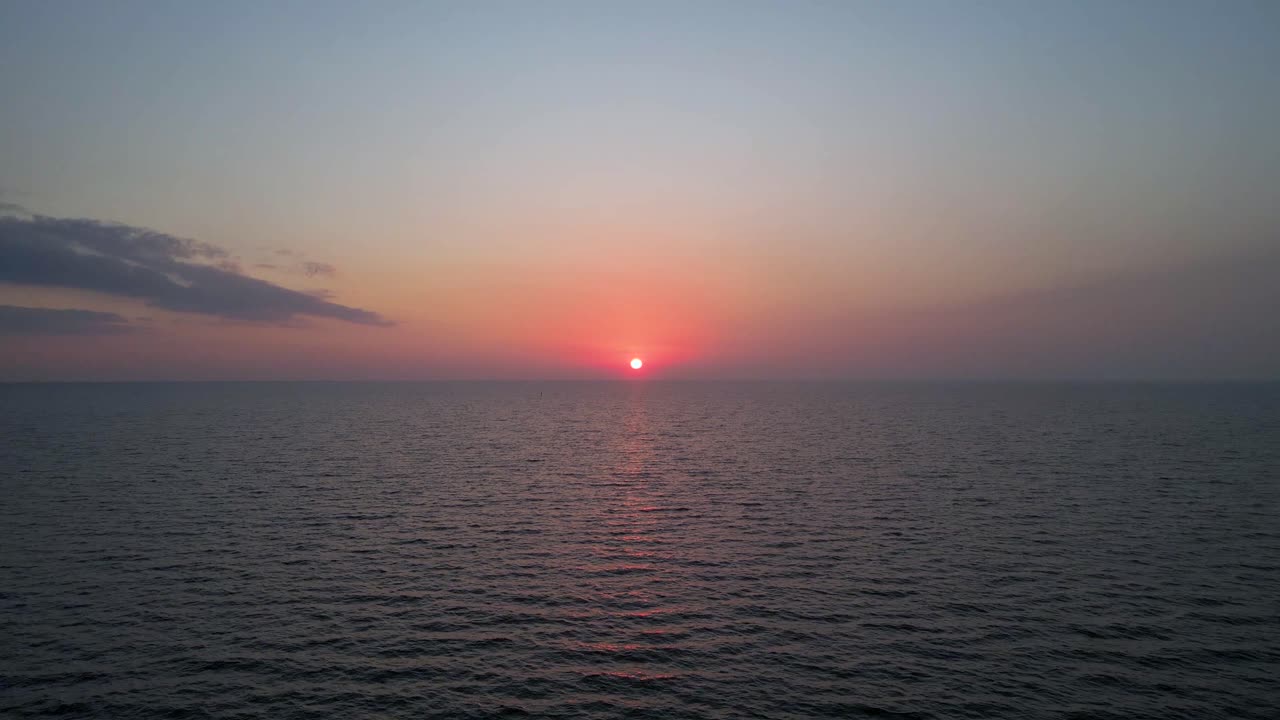 드론은 물 위에서 떠오르는 태양을 향해  ⁇ 습니다.