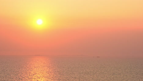 Una-Puesta-De-Sol-De-Colores-Brillantes-Se-Cierne-Sobre-Una-Isla-Tropical-Brumosa-En-El-Horizonte