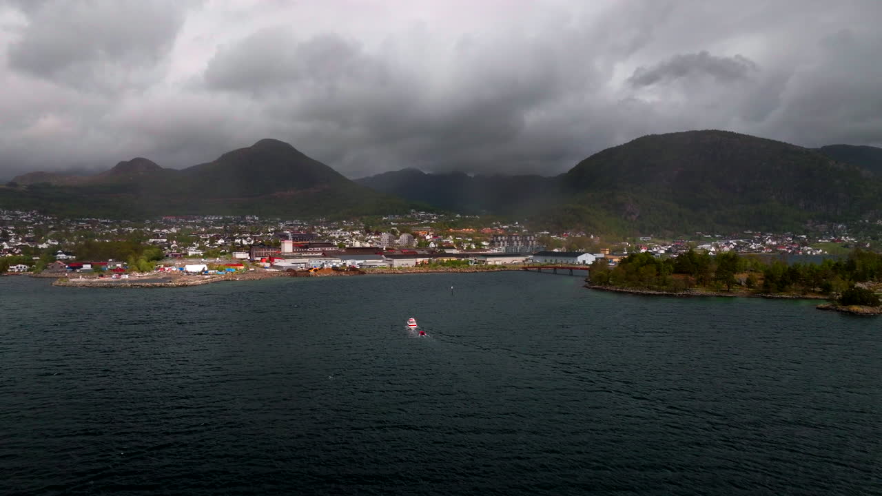 Boat Sailing In The Ocean Towards The Jorpeland City On An Overcast Day In Norway. - aerial shot