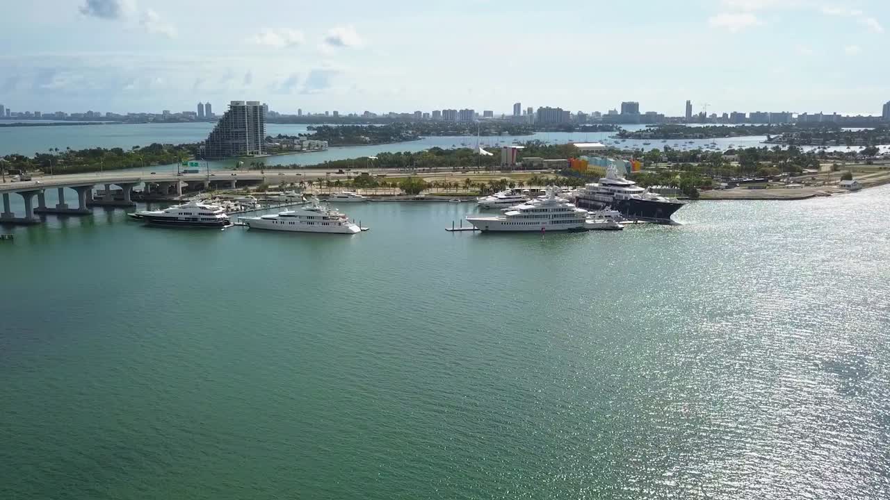 vista aérea hacia yates grandes y caros, en los soleados jardines de la isla, miami, ee.uu. - acercándose, disparo de drones