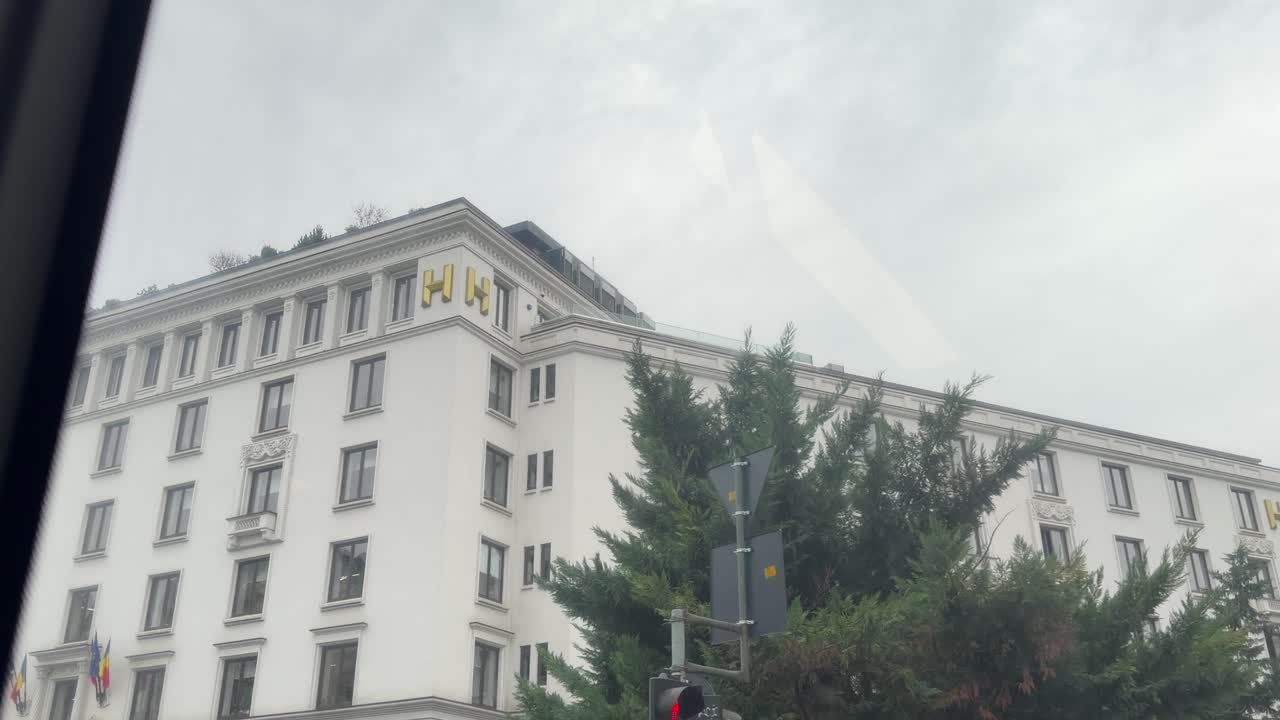 Fachada arquitectónica rumana vista desde un vehículo en movimiento en Bucarest