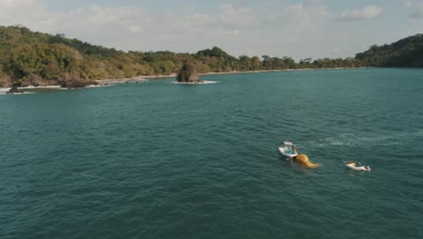 toma aérea de drones de un bote y un jet-ski en la playa en costa rica