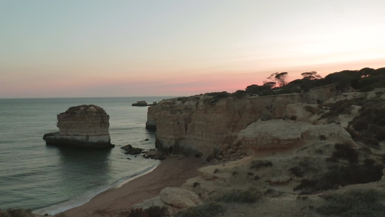 el atardecer costa de las olas que alcanzan la costa en albufeira, portugal