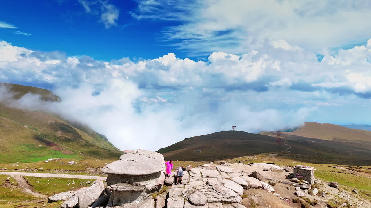 Stone boulders on grassy Caraiman slopes. Large boulders scatter across the grassy slopes of Caraiman Mountain under a bright sky