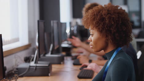 group of college students with tutor studying computer design sitting at monitors in classroom