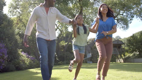 playing in park, parents swinging children by their arms, enjoying family time