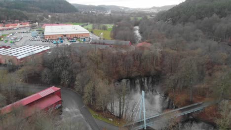 aerial shot of industrial buildings and park with river in a town during winter, sweden