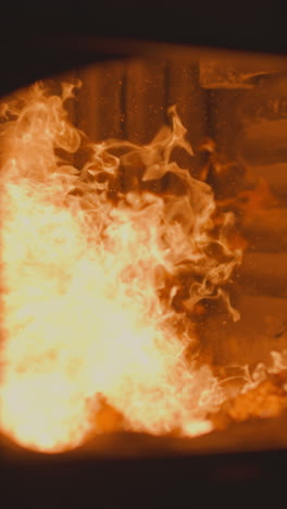 burning charcoal in industrial furnace chamber with open door at metalworking factory. flammable fossil fuel in direct fired heater used in boiler room