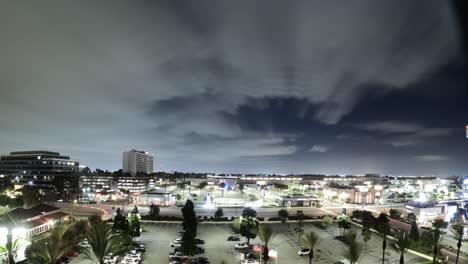 twilight cityscape with moving traffic and illuminated buildings, cloudy and clear sky above, timelapse