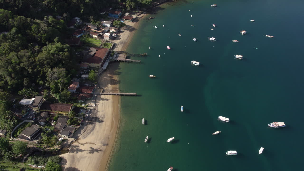 vista aérea de una playa y barcos amarrados en la costa de ilha grande, soleado brasil