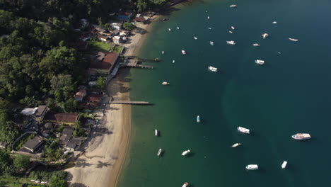 Aerial-view-of-a-beach-and-moored-boats-on-the-coast-of-Ilha-Grande,-sunny-Brazil