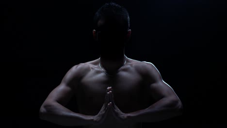 muscular man in meditation pose silhouette