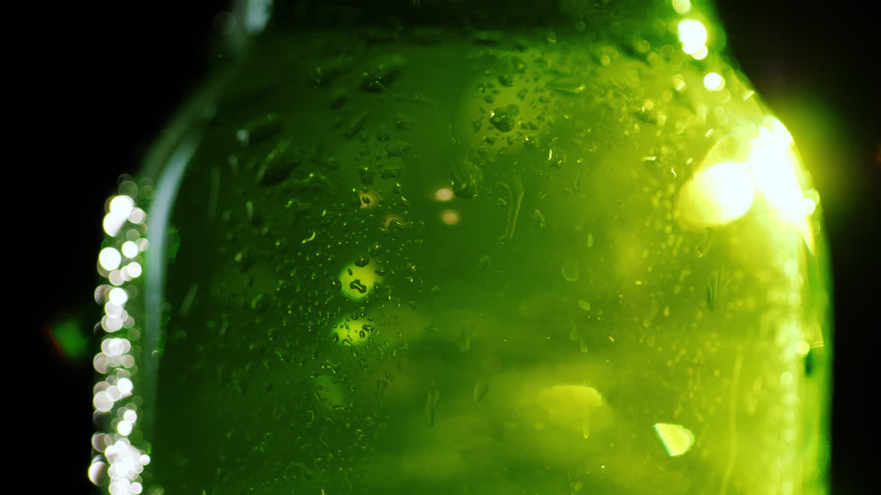 salpicaduras de agua fría caen sobre una botella de vidrio con un refresco o cerveza para saciar su sed concepto 4