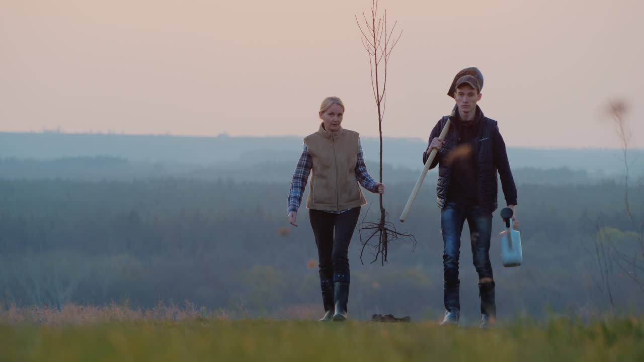 un par de granjeros con una plántula y una pala van a plantar un árbol
