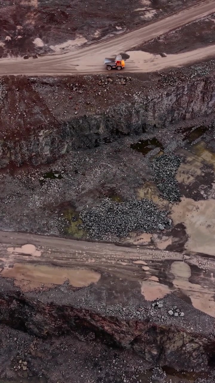 Aerial View of Dump Truck Driving Through Industrial Quarry