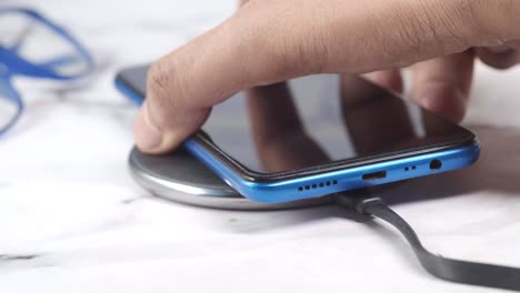 hand placing a smartphone on a wireless charging pad