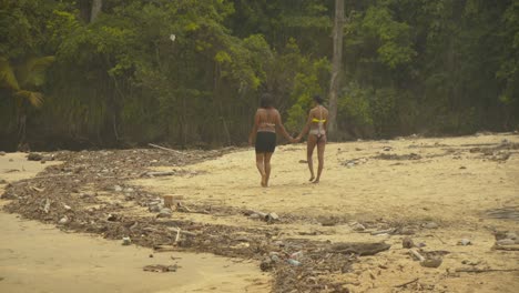 Zwei-Mädchen-Gehen-Händchen-Haltend-Den-Strand-Entlang