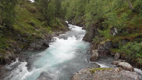 Beautiful-Norway-Highlands-glacier-meltwater-cascading-down-mountainside,-aerial