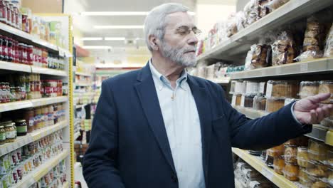 hombre maduro con cesta de compras en la tienda de comestibles