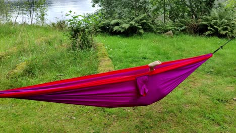 funny clip of young girl playing around inside purple hammock - handheld outdoor in nature