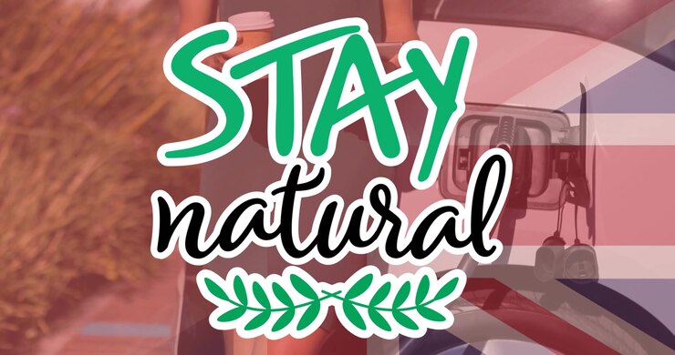 Stay natural text over flag of great britain and woman charging electric car