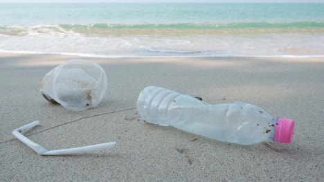 basura de basura plástica se sienta en una playa cerca del océano tropical