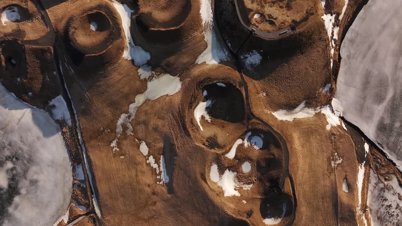 Veduta aerea dall'alto che mostra pseudocrateri circondati dalla neve raggruppati vicino al Lago Mývatn a Skútustaðir. Reykjahlíð, Islanda
