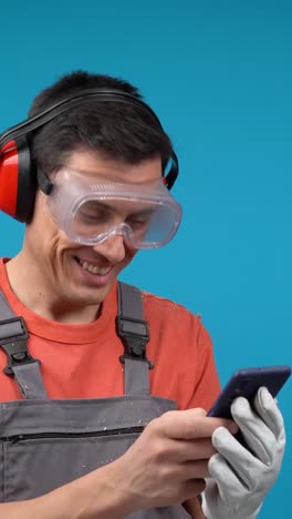 man in safety gear happily checking his phone