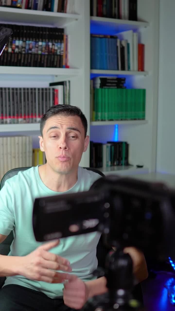 Man recording video in front of bookshelf