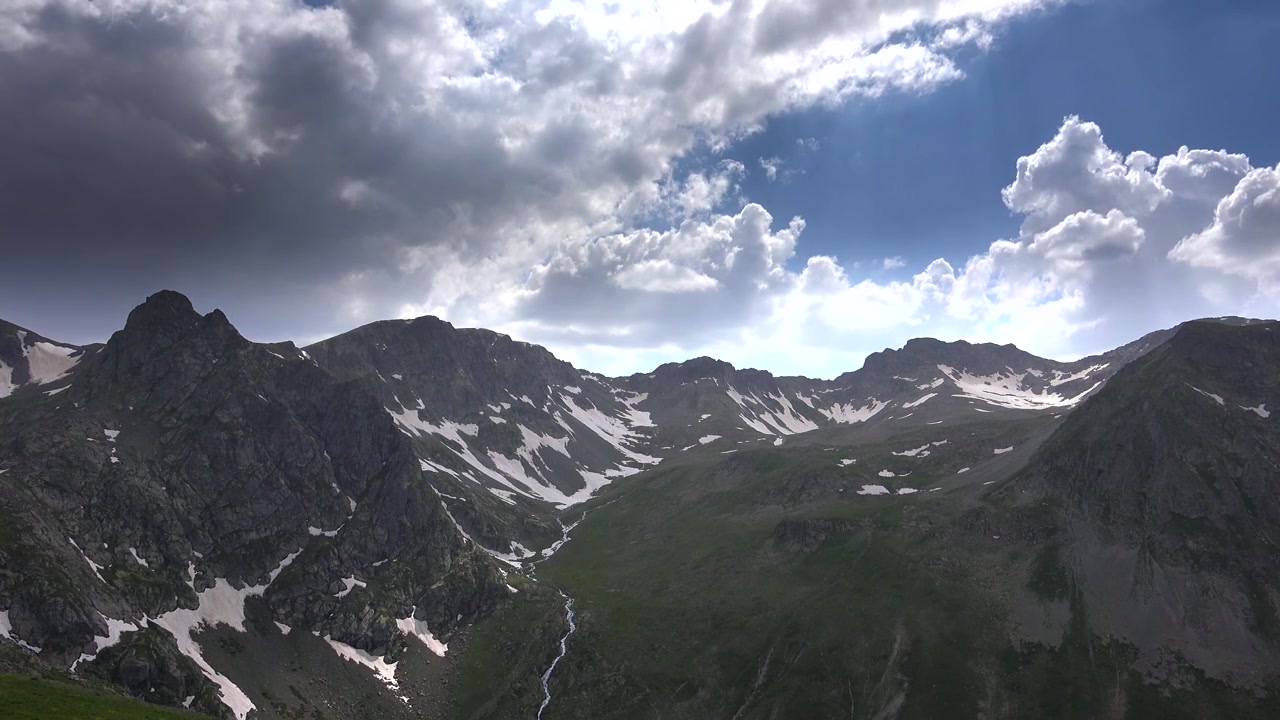 Majestic Mountain Range with Snow-Capped Peaks and Dramatic Clouds