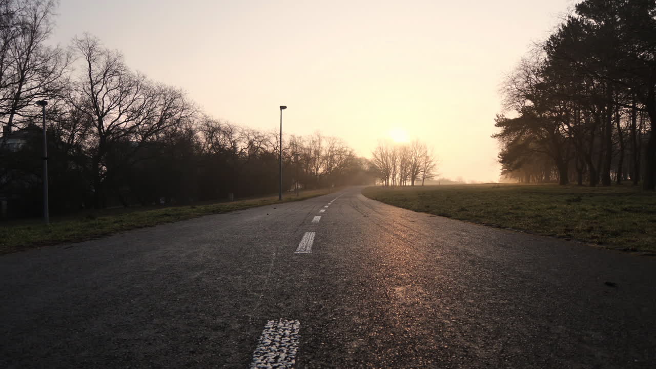 일출 햇빛에 교외의 빈 도로, 영화 같은 낮은 각도 보기
