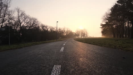 carretera vacía en los suburbios a la luz del sol del amanecer, vista cinematográfica de ángulo bajo