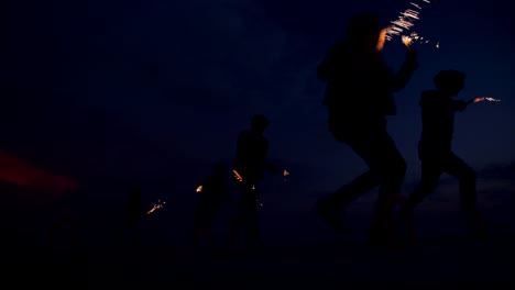 partying teens enjoying their time together with fireworks after sunset
