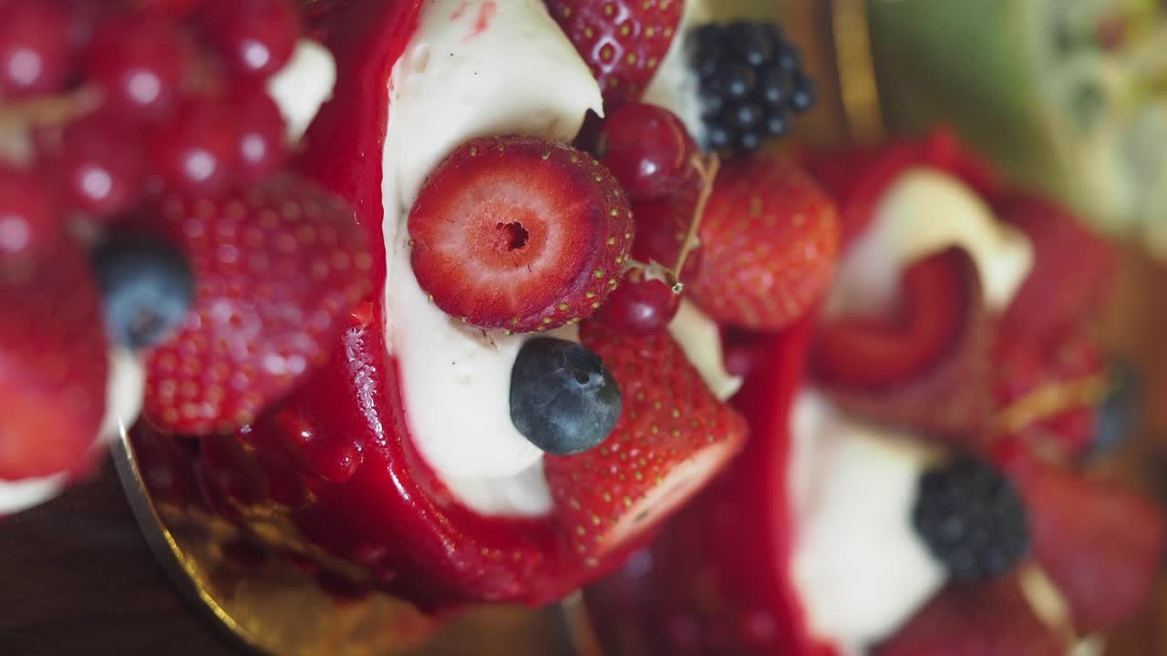 Close-up of a delicious fruit cake decorated with strawberries, blueberries, blackberries, and red currants.