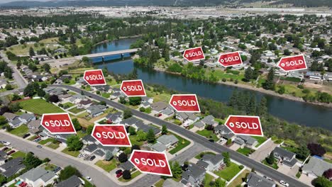 drone shot of sold signs popping up over recently sold houses in a suburban neighborhood