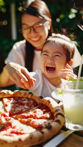a family enjoying a joyful outdoor pizza meal on a sunny day